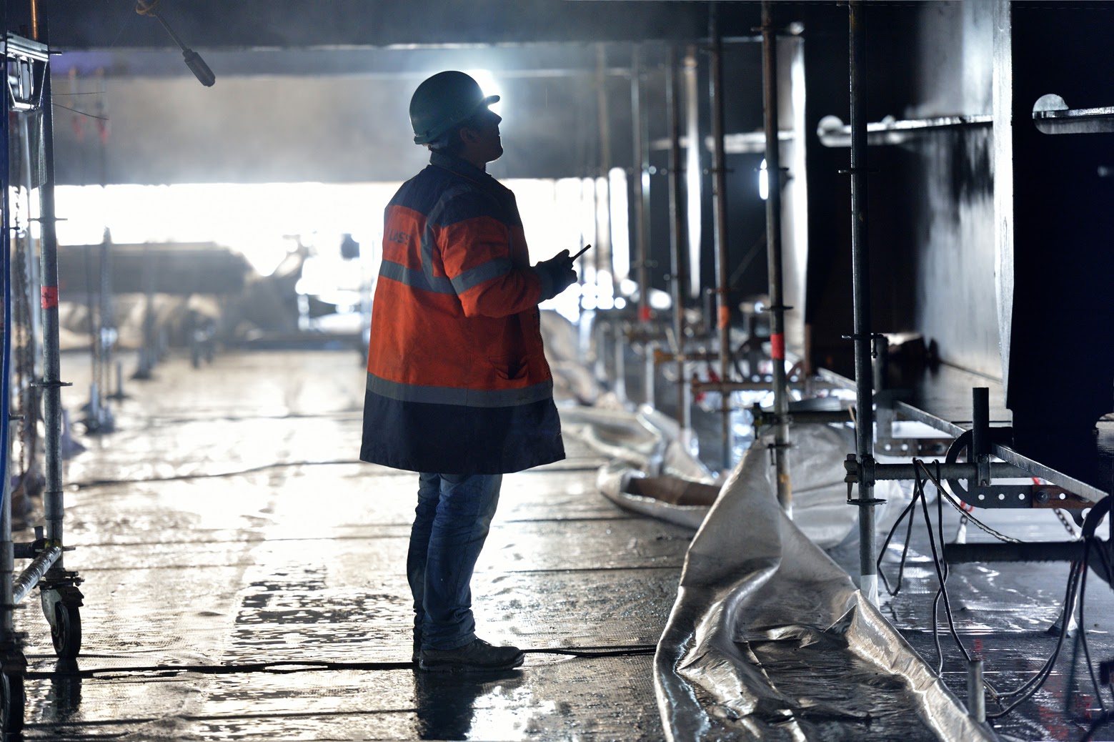 Photo of a worker inspecting a metal structure.
